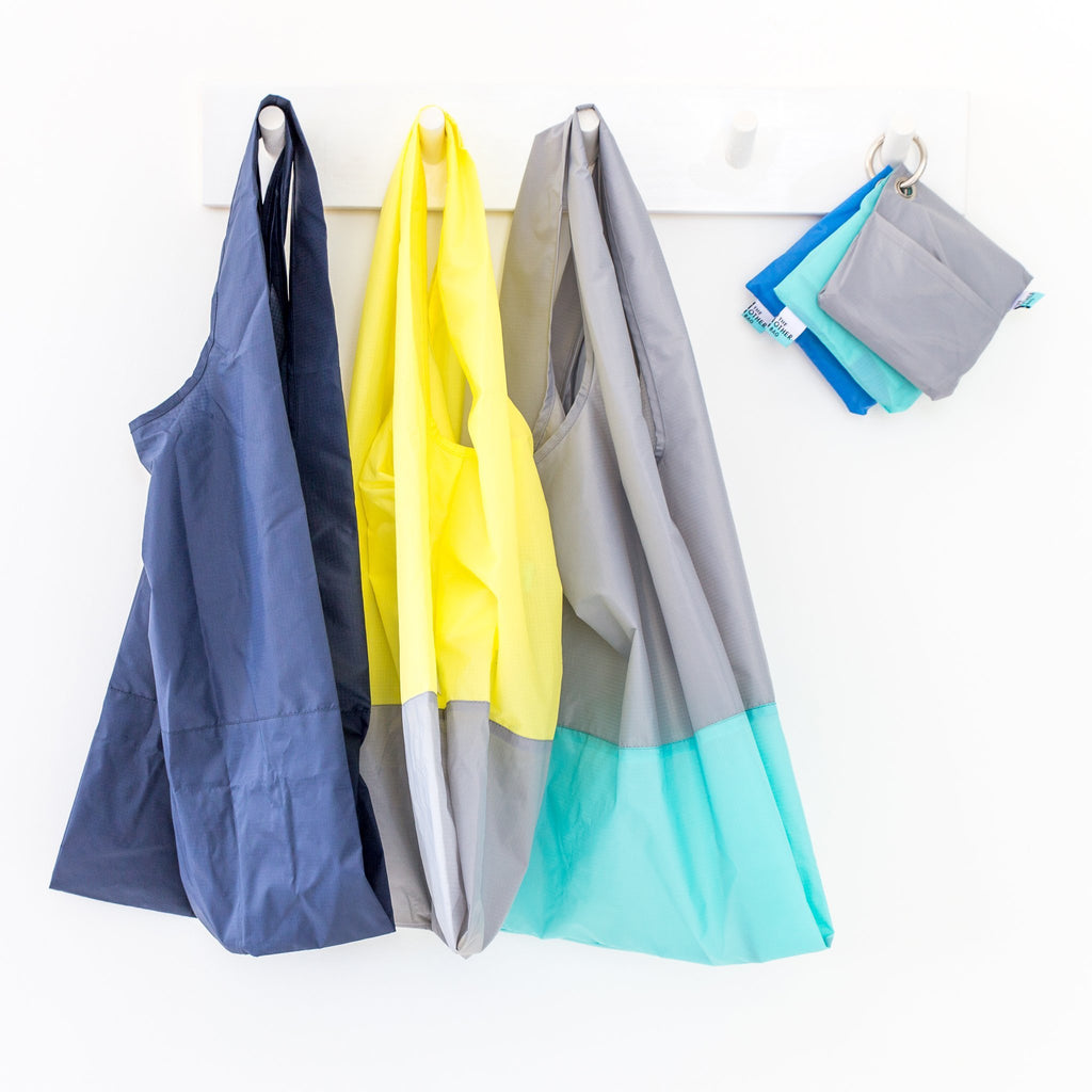 Various recycled foldable tote bags hanging