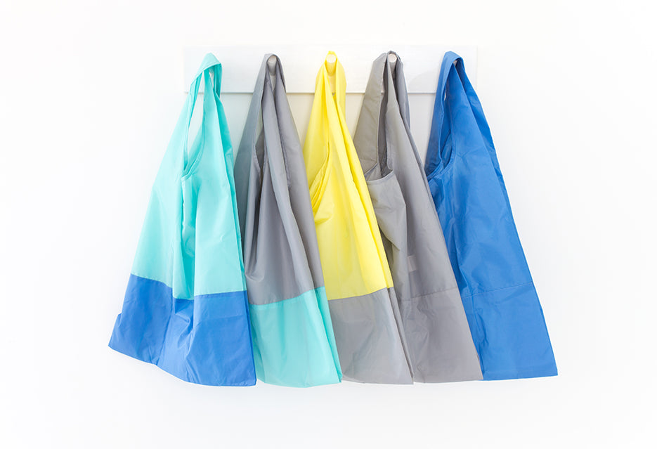 Collection of recycled foldable tote bags in a row